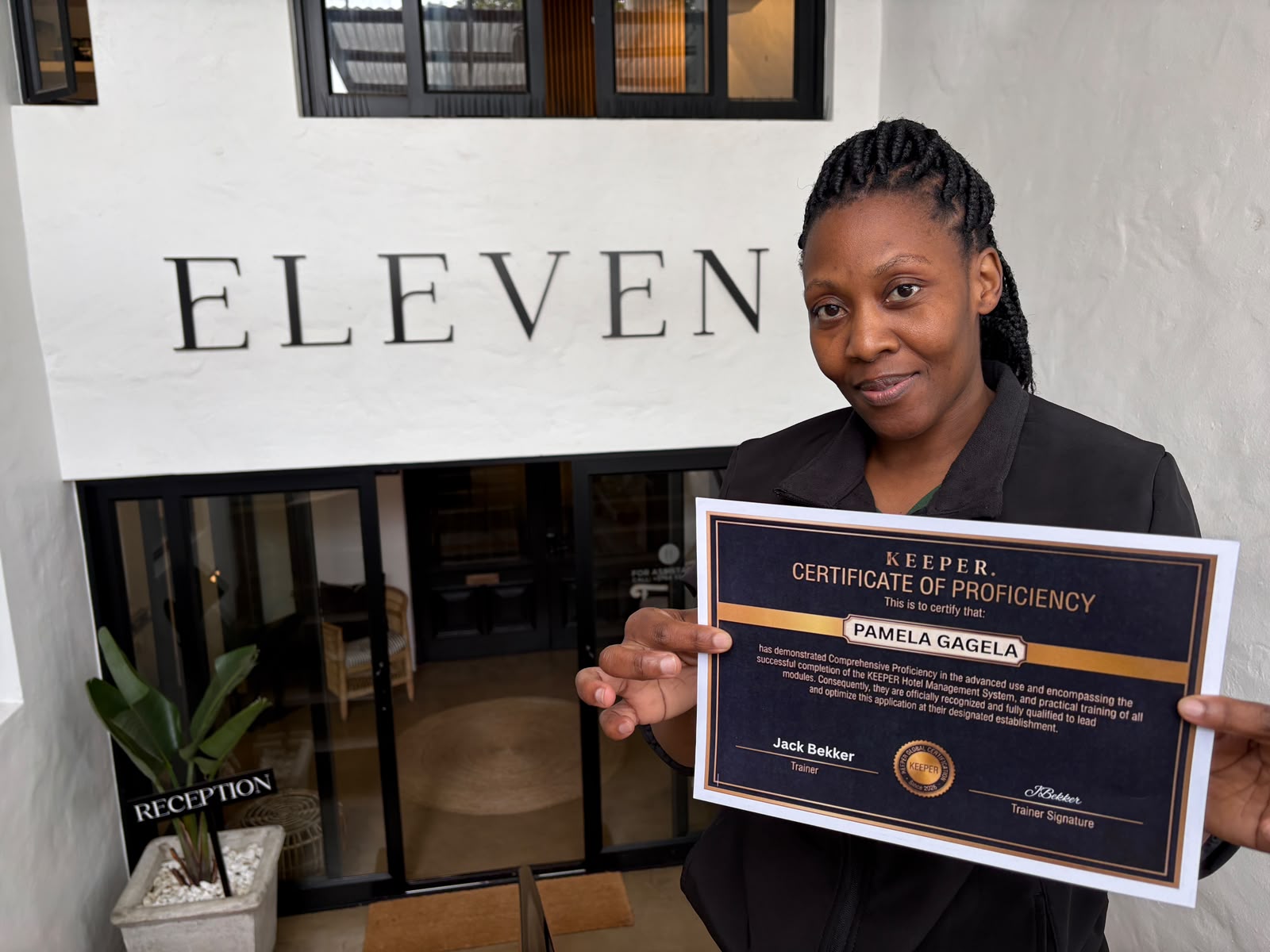 Pamela Gagela holding her Keeper Certificate of Proficiency outside Eleven Hotel